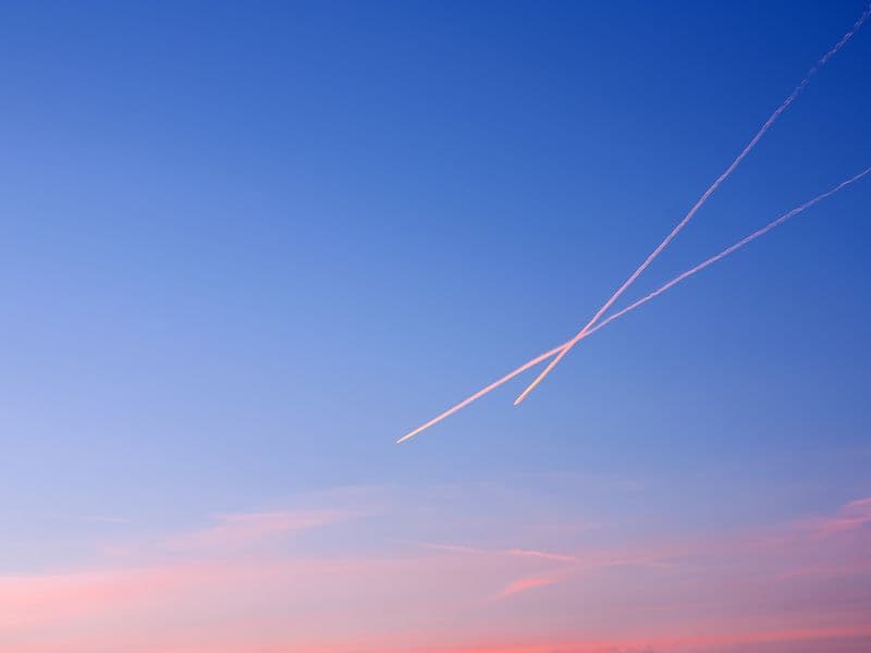 Aircraft contrails crossing the sky at sunset